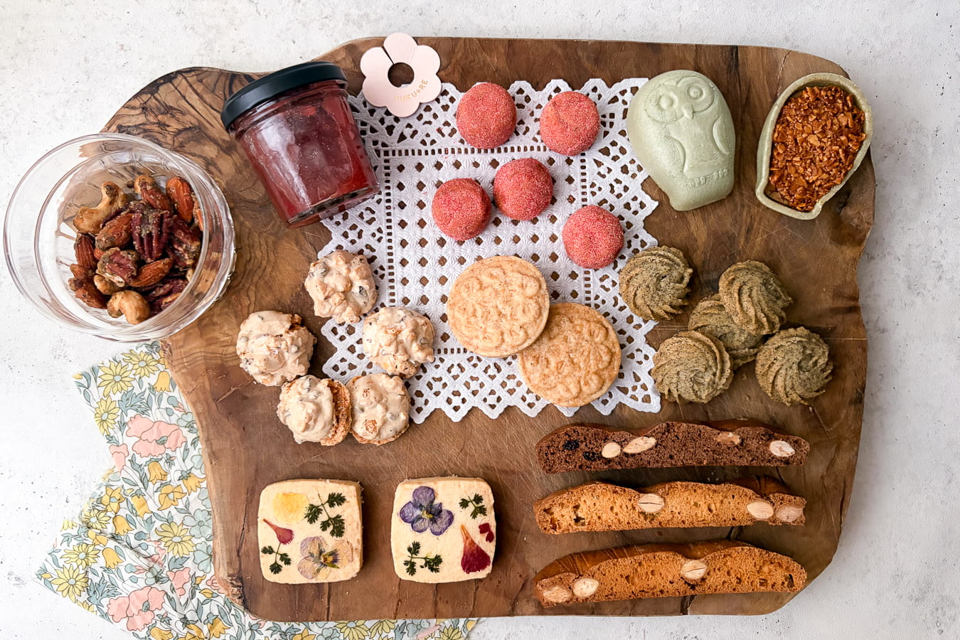 母の日ギフト特集ページのバナー画像。カーネーションを添えた焼き菓子と蒸し菓子の詰め合わせを俯瞰で撮影し、春らしい淡いピンクとベージュのトーンで仕上げた贈り物のシーン