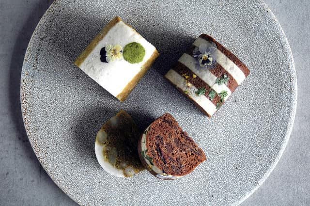 小皿に盛ったDuo Bセットのふくれ菓子。緑茶とココアの色の違いが鮮やかで、花びらの飾りが彩りを添えるおしゃれな2種ギフト。