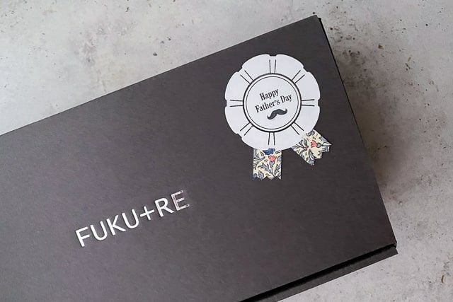 父の日用のロゼットシールが貼られた、FUKU+REの黒いギフトボックスの外観の寄り写真