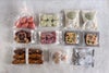 透明な袋に個包装された焼き菓子の詰め合わせ。クッキー、フロランタン、フクロウ型の焼き菓子、白い丸い菓子などが並び、上から撮影されている。