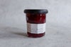 深い赤色のジャムが詰まったガラス瓶の商品写真。シンプルなラベルと上質な色味が際立ち、ギフトにも適した印象。